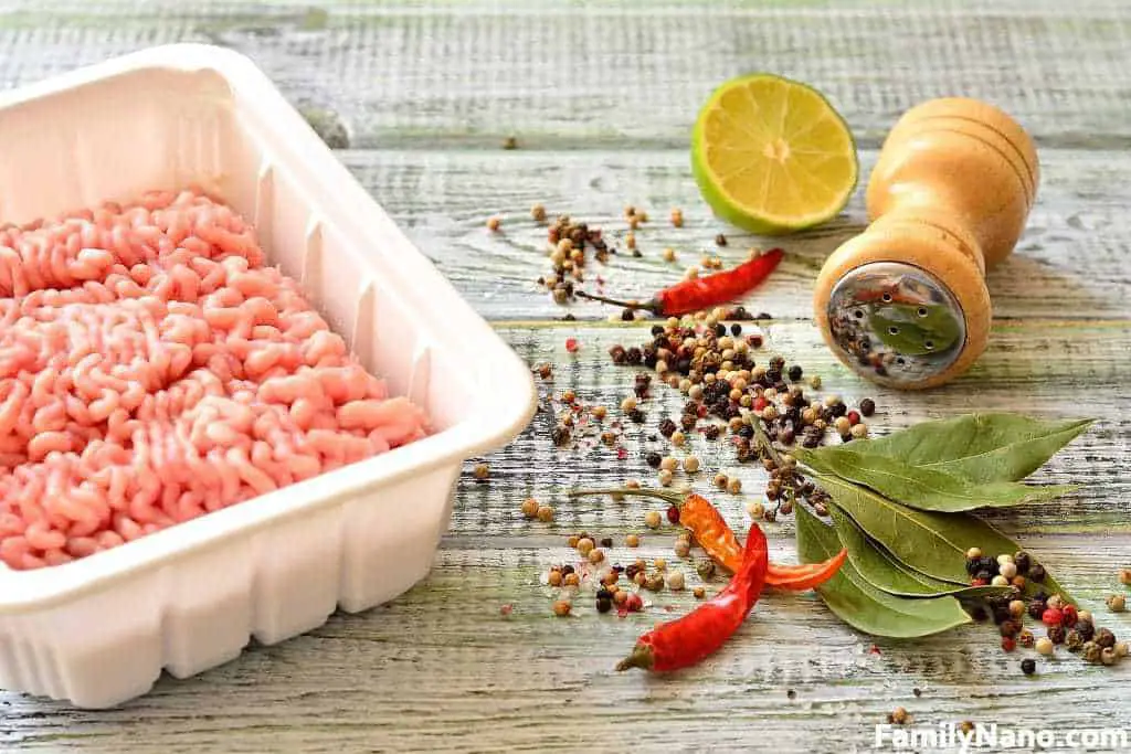 Minced meat with spices on the wooden table