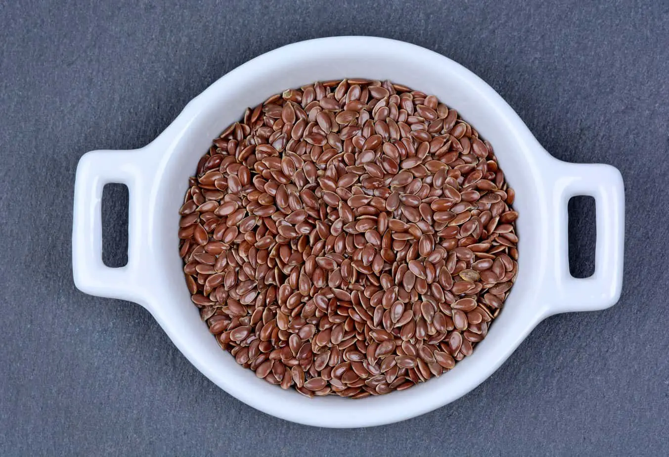 Flax seeds in a ceramic bowl on slate