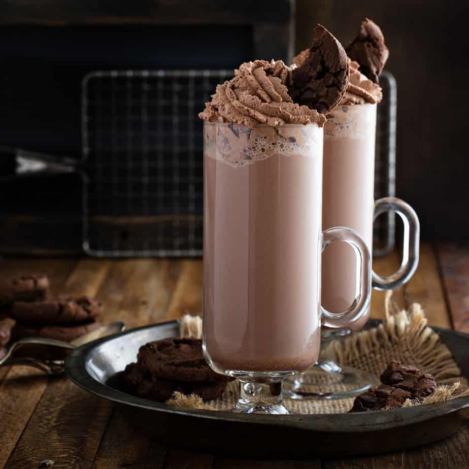 Chocolate cookie milkshake in tall mugs with chocolate whipped cream