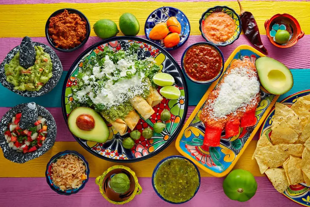 Green and red enchiladas with mexican sauces mix in colorful tab
