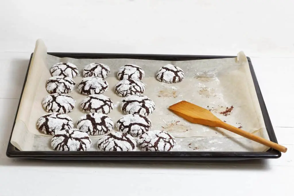 Homemade chocolate crinkle cookies on a baking sheet