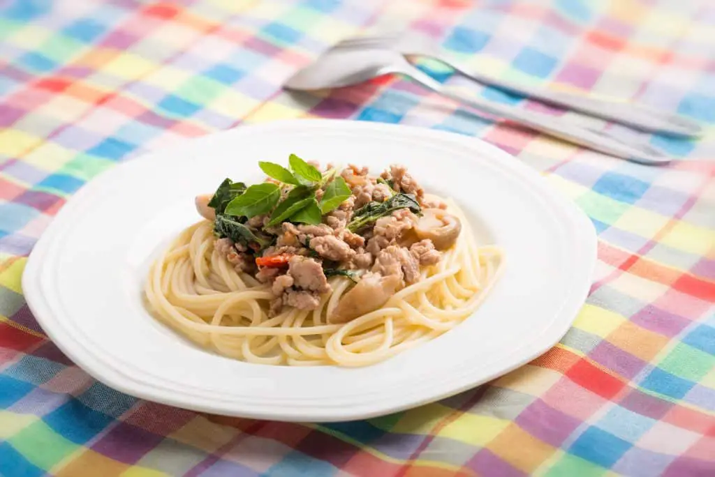 Spaghetti topped with stir-fried pork and basil