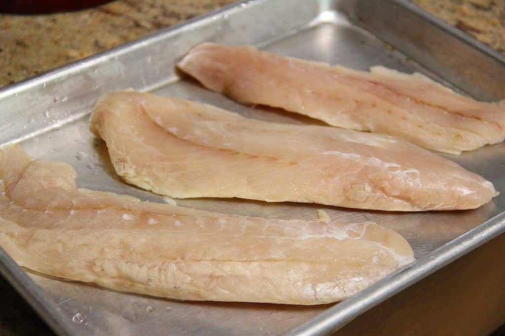 raw fish on a foil-lined baking sheet